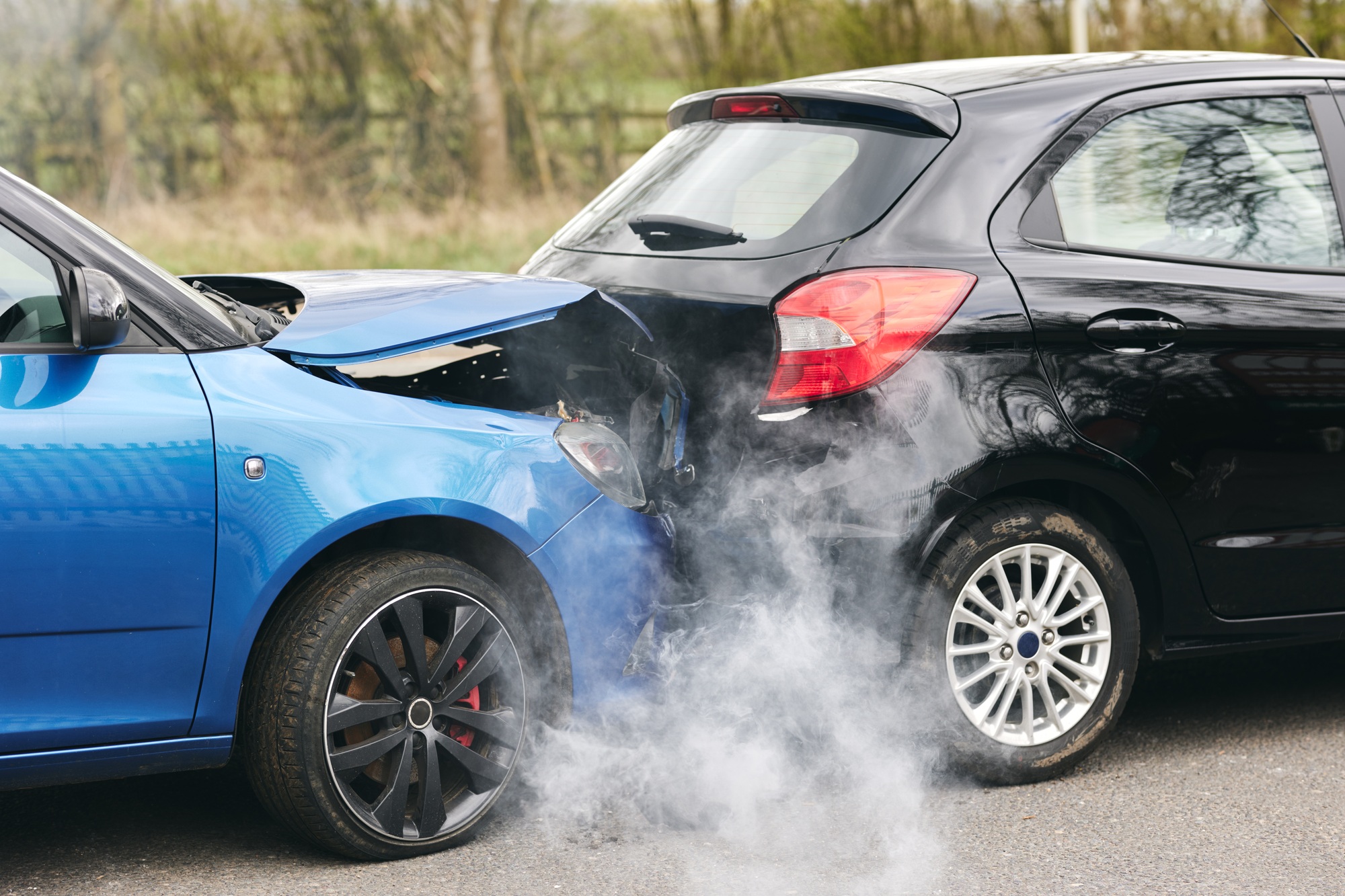 Two Damaged Cars Involved In Road Traffic Accident Showing Smoke After Collision
